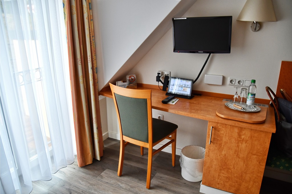 Schreibtisch mit Fernseher und Tablet in einem Hotelzimmer. Foto: Frau Mohnblume
